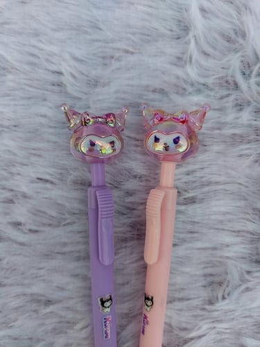 Close-up of cute purple and pink character-topped pens, a signature kawaii stationery find