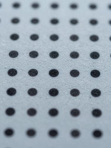 Extreme close-up of a printed substrate surface, ink dots and texture sharply resolved under cool studio daylight, color accuracy visible at material level, tight macro framing from directly above