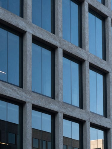 A sharp architectural crop of a modern office building exterior in Logan Utah under crisp cool daylight, concrete and glass details