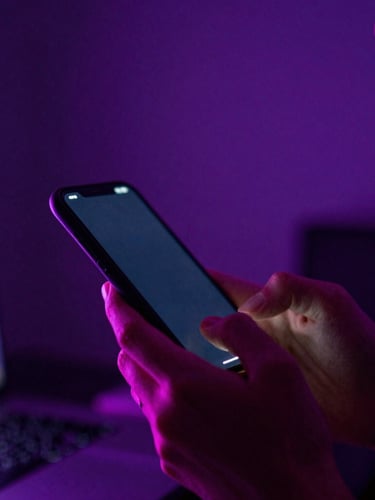 A high-energy close-up of a creator holding a glowing phone, neon purple and pink backlighting, 35mm film grain.