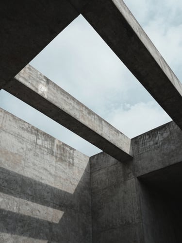 Extreme wide-angle architectural shot of concrete and steel geometry under cool overcast daylight, sharp structural shadows, minimal composition.