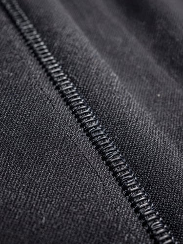 Macro shot of a patch border showing the tight overlock merrow stitch on heavy canvas, side lighting.