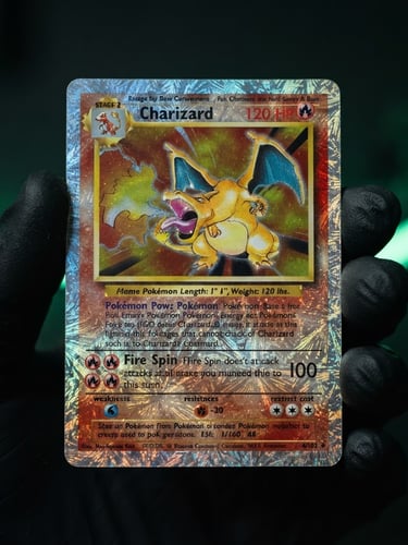 Macro photograph of a rare holographic Pokémon card held by hands in black protective gloves, focused on the pristine foil texture, dark studio background with soft green neon light.