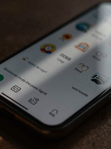 Macro crop of an app interface on a hand-held mobile device in low-key natural light, high-contrast shadows, warm tones
