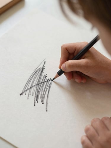 A child's hand holding a thick graphite pencil, drawing bold expressive lines on textured paper, soft natural daylight, warm tones.
