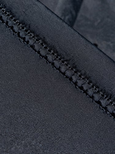 Close-up macro shot of double-stitched UV-stabilized polymer fabric texture under direct Abu Dhabi sunlight, highlighting the heavy-duty weave and structural integrity.
