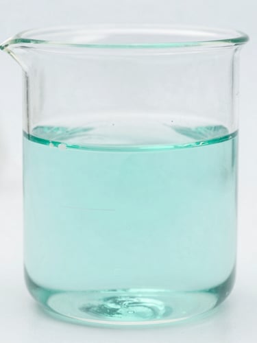 Macro shot of a clear liquid in a scientific beaker, precise laboratory setup, clean white background, cool-toned natural daylight.