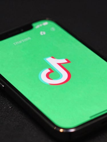 Extreme close-up of a smartphone screen displaying a high-retention TikTok video, vibrant neon green interface elements reflecting on the dark glass, dark studio background.