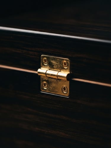 Moody luxury photography, low-key dramatic side-lighting, macro shot of a gold hinge on a dark Spanish cedar humidor, 35mm