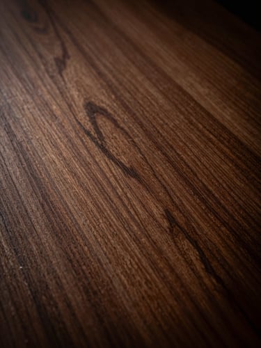 Close-up of raw Spanish cedar wood texture, showing the fine grain and rich warm brown fibers under dramatic side lighting, 35mm