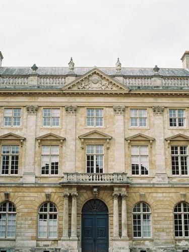 Symmetrical architectural view of a historic European university facade in soft overcast daylight, muted scholarly tones, 35mm film look