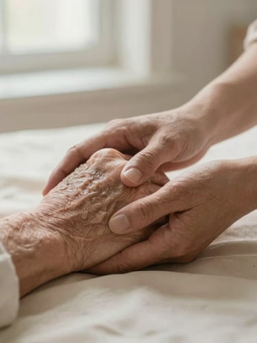 Close-up of supportive hands: a caregiver gently holding the weathered hand of an elderly person on a soft cream fabric background, warm morning light, shallow depth of field.