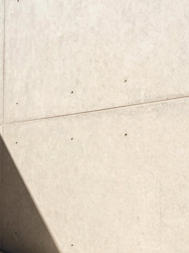 Extreme close-up of a flawless paint finish on a modern architectural concrete wall, crisp desert sunlight casting sharp geometric shadows, 35mm photography