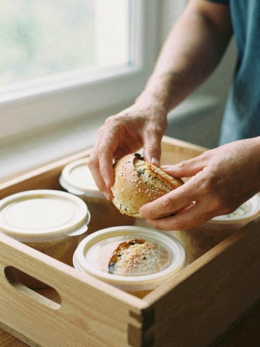 Close-up of a volunteer's hands carefully packing fresh bread and warm soup containers into a wooden delivery box, soft natural window light, earthy organic tones, 35mm film look