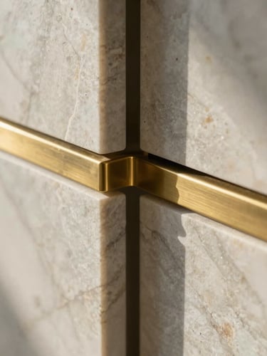 Close-up of raw honed marble and brushed brass joinery, soft morning light highlighting natural stone textures
