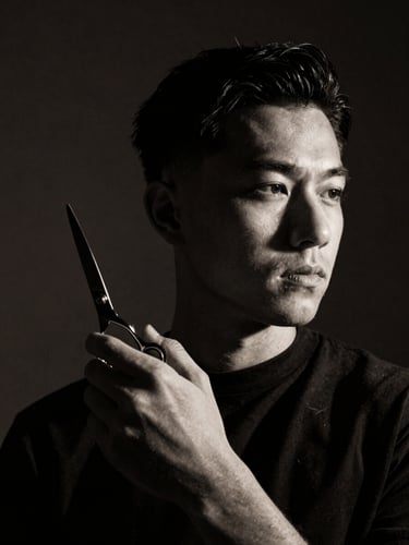 Black and white portrait of a barber holding shears, dramatic side-lighting, deep shadows