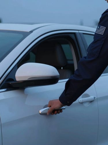 Cinematic close-up of a professional driver in uniform opening a clean sedan door under early-morning blue hour light