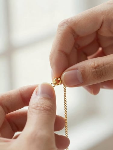 Macro close-up of a hand fastening a warm gold claspless bracelet, soft morning window light, high-key editorial jewelry photography, shallow depth of field.