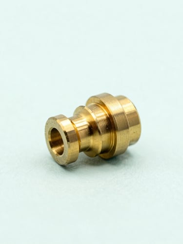 A minimalist, clean close-up of a high-precision brass custom component resting on a soft pastel mint background, diffused natural light, sharp focus.