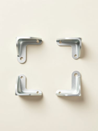 Overhead minimalist flat-lay of custom machined aluminum brackets on a soft pastel cream background, clean studio lighting, 50mm
