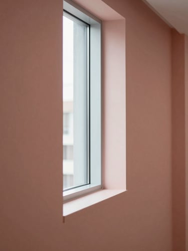 Minimalist architectural detail of a modern healthcare facility corridor, soft natural window light, clean lines, muted warm slate and rose tones.