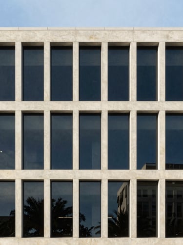 Clean architectural photography of a modern, minimalist concrete and glass office facade in Florida, sharp structural lines, bright morning daylight, desaturated tones, 35mm lens
