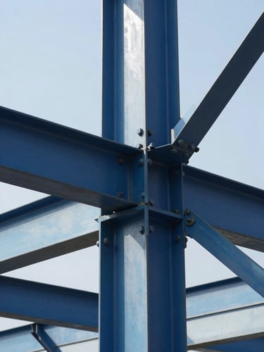Sharp close-up of structural steel joints and heavy bolts on an industrial framework, crisp architectural shadows, bright daylight, high contrast