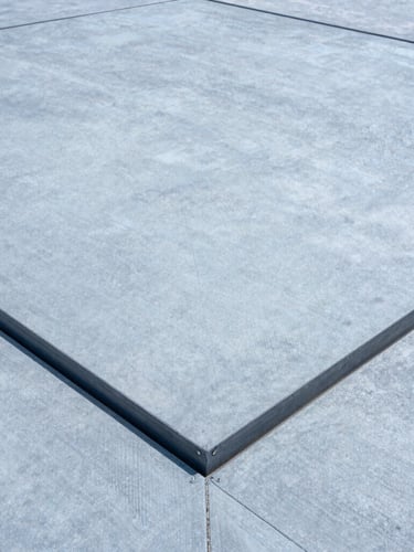 Close-up of a large expansion joint cover seamlessly integrated into a modern concrete floor, crisp daylight, cool tones, showing material texture and precise installation, wide-angle.
