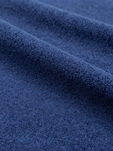 Macro photograph of heavy navy blue cotton fleece fabric, clean industrial daylight, sharp weave texture, 35mm