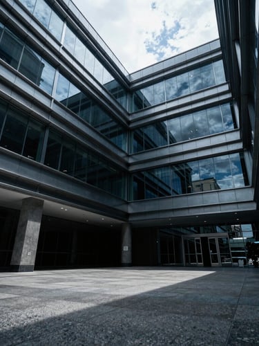 Wide-angle low-key dramatic shot of a luxury corporate office interior in León, Guanajuato, sharp architectural lines of steel and glass, polished concrete, deep shadows, cool daylight, cinematic corporate photography, 35mm