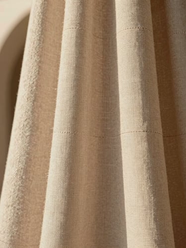 Close-up of premium woven linen fabric, showing intricate stitching and architectural drape, soft diffused daylight, warm editorial photography, 35mm