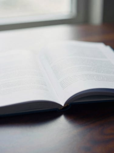 Tight, off-center macro shot of an open academic white paper on a dark wooden table, soft overcast daylight from a window, shallow depth of field, 35mm film