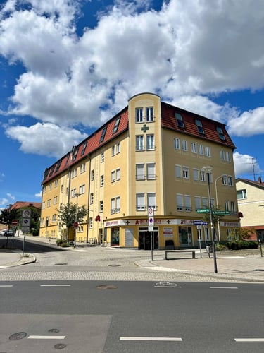 Gelbes Ärztehaus mit angeschlossener Apotheke – Außenansicht des Standorts der Hausarztpraxis