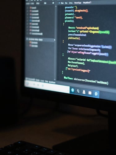 Macro close-up photography of a clean developer workstation in Bangkok, cool-toned low-key ambient lighting with a subtle green glow from a vertical monitor displaying clean code blocks, shallow depth of field