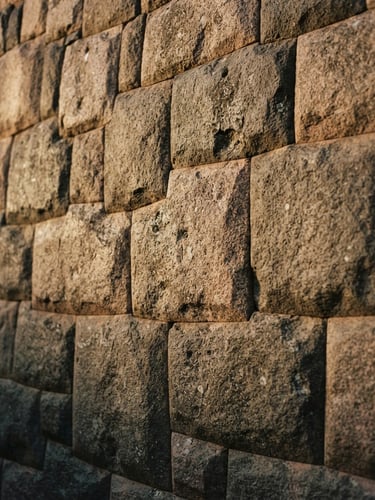 A close-up of ancient Inca stone masonry in Ollantaytambo, warm golden hour light hitting the detailed textures, 35mm film style.
