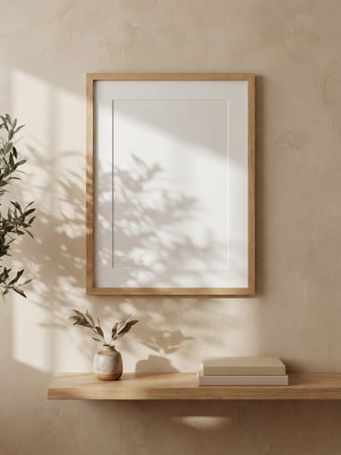 Straight-on architectural shot of an empty oak frame on a textured beige plaster wall, soft morning window light casting delicate leaf shadows, warm-minimalist interior, 35mm