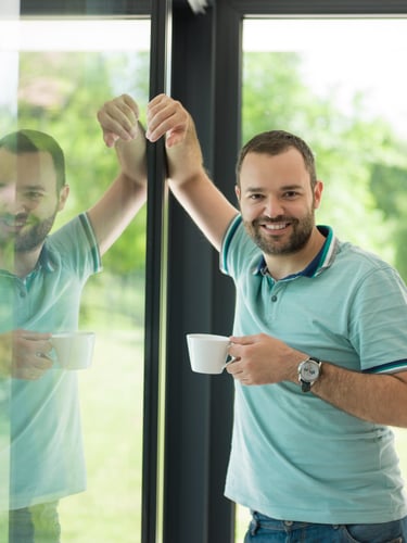 a man is holding a cup of coffee and a cup of coffee
