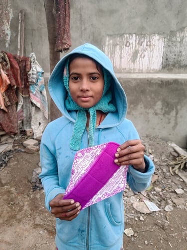 Young girl holding up a Hanaru reusable sanitary napkin