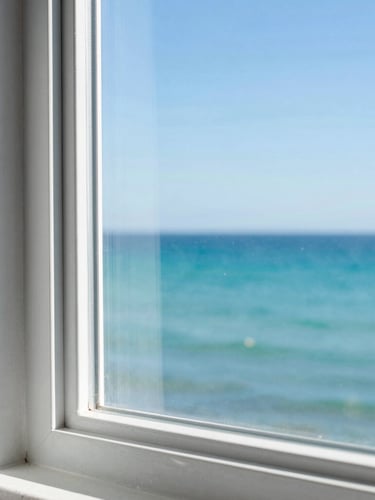 A close-up of a sparkling clean glass window frame overlooking the bright turquoise Broome coast, crisp sunny daylight, sharp focus, 35mm