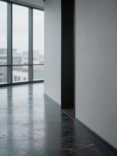 Close-up architectural detail of a contemporary office corridor, polished dark stone flooring reflecting diffuse window light, clean geometric lines, minimal furnishing, no people, cold and precise atmosphere, overcast daylight