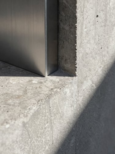 Extreme close-up of raw concrete meeting brushed steel in a minimalist architectural joint, sharp shadows, high-contrast natural light