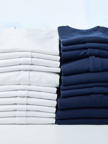 Bright commercial product photography of neatly folded garment stacks in crisp white and navy tones, studio lighting, high detail, 50mm