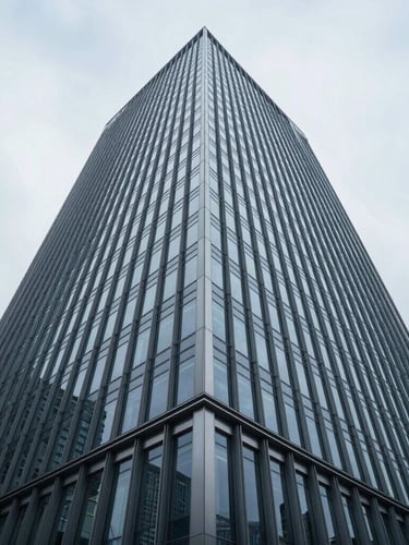 Wide-angle architectural crop of a modern steel and glass skyscraper facade reflecting cool overcast daylight