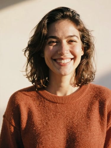 Candid, joyful shot of a woman wearing a warm terracotta sweater in natural golden-hour sunlight, smiling genuinely, 35mm film look.