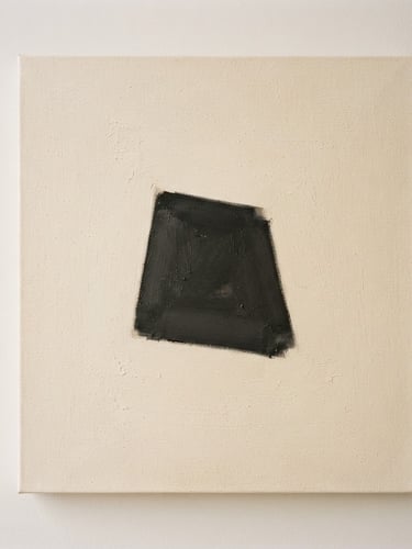 Straight-on fine art photography of a minimalist oil painting on textured canvas, a single charcoal geometric form on a warm ivory background, soft diffused window light