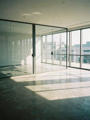 Interior shot of a freshly cleaned commercial office space, sparkling glass surfaces, polished concrete floor, natural daylight streaming in, clean and modern aesthetic, realistic documentary style, 35mm