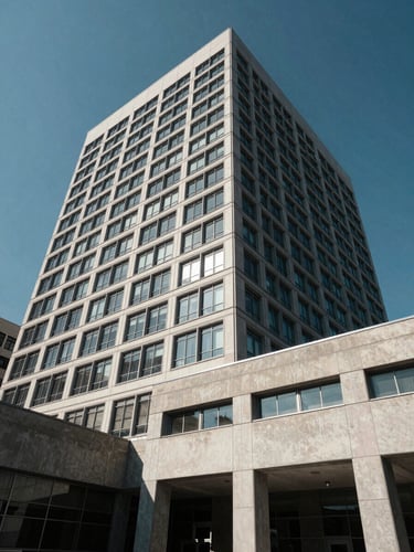 Stark architectural exterior crop of an institutional headquarters, harsh midday sun, sharp shadows on concrete and steel, wide cinematic angle emphasizing physical presence and security.