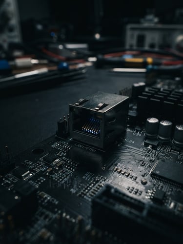 Macro close-up of an RJ45 ethernet port on a dark server motherboard, sharp blue highlights, moody studio lighting, dark workbench background, 35mm lens