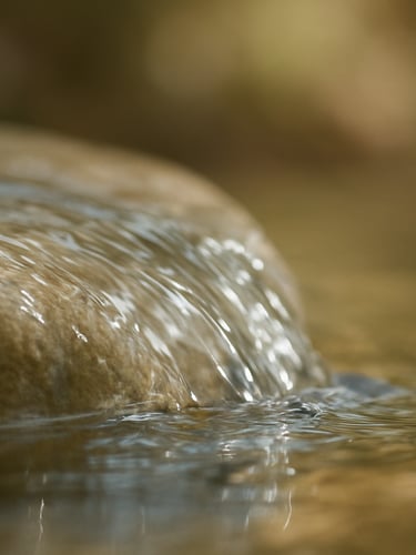 Close-up of crystal-clear spring water flowing over rocks, pure and naturally balanced
