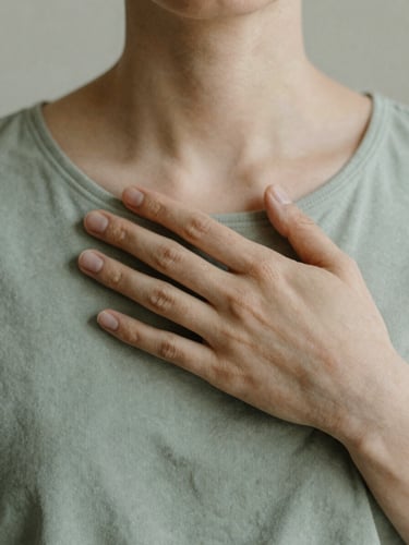 A close-up of hands resting gently on a chest, soft morning daylight, muted sage green and sand tones, minimalist composition, shallow depth of field
